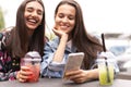 Young girls friends watch something in smartphone. Royalty Free Stock Photo