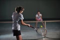 Young girls playing tennis game indoor