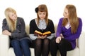 Young girls read fiction on couch