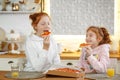 Young girls with red hair in the kitchen eating pizza, drinking juice. Get-togethers with girlfriends, two sisters Royalty Free Stock Photo