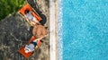 Young girls relax near swimming pool in sunbed deckchairs, women friends have fun on vacation in hotel resort, aerial view Royalty Free Stock Photo