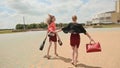 Young girls running with a barefoot pleasure, having finished the working day. Holding shoes and bags.