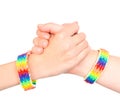 Young girls shaking hands with a bracelet patterned as the rainbow flag. isolated on white background Royalty Free Stock Photo
