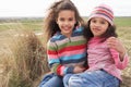 Young Girls Sitting Amongst Dunes On Winter Beach Royalty Free Stock Photo