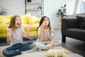 Young girls sitting on floor and having fun. Brunette making luftbolper. Another teenager try to catch them. She rejoice. Royalty Free Stock Photo