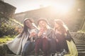 Young girls sitting on the stairs at the public park. Thre Royalty Free Stock Photo