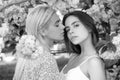 Young girls and spring flowers. Portrait of a two beautiful young women relaxing in sakura flowers. Lesbian couple Royalty Free Stock Photo