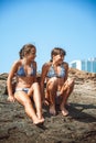 Young girls on stones on a beach