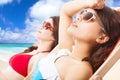 Young girls sunbathing and lying on a beach chair