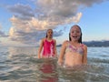 Young girls swimming in the wave with splash. Happy children, summer vacation concept Royalty Free Stock Photo