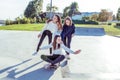 Young girls teenage schoolgirls ride skateboard summer park. Casual wear sweater jeans. Emotions happiness, fun