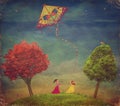 Young girls among trees on the field with kite