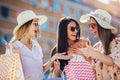 Young girls walking the street with shopping bags. Happy shopping with smiles Royalty Free Stock Photo