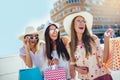 Young girls walking the street with shopping bags. Happy shopping with smiles Royalty Free Stock Photo