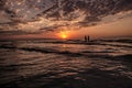 Young girls in warm water at sunset. Gorgeous colors in the sky and the sea. People standing and watching to sunset at Caspian sea Royalty Free Stock Photo