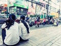 Young girls watching passers by in Bangkok