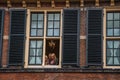 Young girls at window in the Binnenhof Gothic public buildings at The Hague.