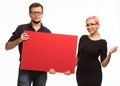 Young glad couple showing presentation pointing placard