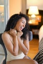 Young gladden black girl sitting in room and wearing beige lingerie. Royalty Free Stock Photo