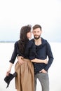 Young gladden couple hugging each other and wearing fashionable clothes in white monophonic winter background. Royalty Free Stock Photo