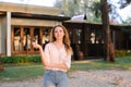 Young gladden woman standing near resort house and keeping keys. Royalty Free Stock Photo