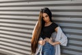 Young glamorous elegant woman in round sunglasses with long hair in a black fashionable t-shirt in a vintage summer jacket Royalty Free Stock Photo