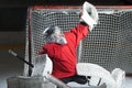 Young goalkeeper catching a puck