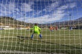 A young Goalkeeper caught in action is preparing himself to challange the opponent