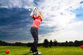 Young golf player on course doing golf swing Royalty Free Stock Photo