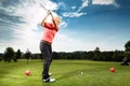 Young golf player on course doing golf swing Royalty Free Stock Photo