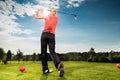 Young golf player on course doing golf swing Royalty Free Stock Photo