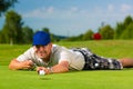 Young golf player on course putting Royalty Free Stock Photo