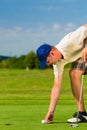 Young golf player on course putting Royalty Free Stock Photo