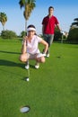 Young golf woman looking and aiming the hole