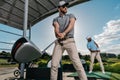 Young golfers with clubs playing golf together