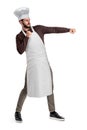 A young good-looking chef in a chef hat and apron posing with clenched fists and left hand held out as if about to hit Royalty Free Stock Photo