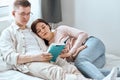 Young good looking couple enjoing reading a book in the evening