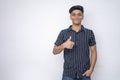 Young good looking man wearing a half shirt showing thumps up looking into the camera standing a white background