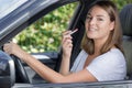 young good-looking woman applying lipstick in car Royalty Free Stock Photo