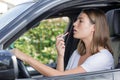 young good-looking woman applying lipstick in car Royalty Free Stock Photo