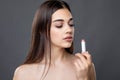 Young beautiful woman tests smell and applying lipstick or lip balm, skin and lips care, Chap protection