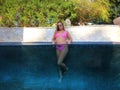 A Lovely Brunette Swimsuit Model Enjoys Her Holiday At The Pool Royalty Free Stock Photo