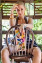 Young gorgeous female painter artist looking and smiling at camera, sitting on an old chair, holding palette and a paintbrush. Royalty Free Stock Photo