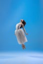 Young and graceful ballet dancer isolated on blue studio background. Art, motion, action, flexibility, inspiration Royalty Free Stock Photo