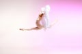 Ballerina. Young graceful female ballet dancer dancing over pink studio. Beauty of classic ballet. Royalty Free Stock Photo