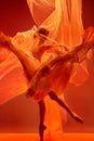 Ballerina. Young graceful female ballet dancer dancing over red studio. Beauty of classic ballet. Royalty Free Stock Photo