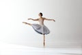 Young graceful woman ballet dancer dressed in professional outfit, shoes and white weightless skirt demonstrating Royalty Free Stock Photo