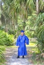 Young Graduate Posing With Cap And Gown In A Tropical Setting