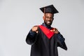 Young graduated african american man cheerful with a smile of face pointing with hand and finger up to the side over isolated Royalty Free Stock Photo