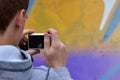 A young graffiti artist photographs his completed picture on the wall Royalty Free Stock Photo